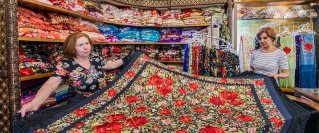 A woman buying a Manila shawl in a shop in Seville A woman buying a Manila shawl in a shop in Seville
