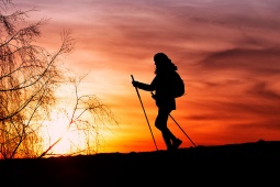 Silhouette einer Pilgerin bei Sonnenuntergang