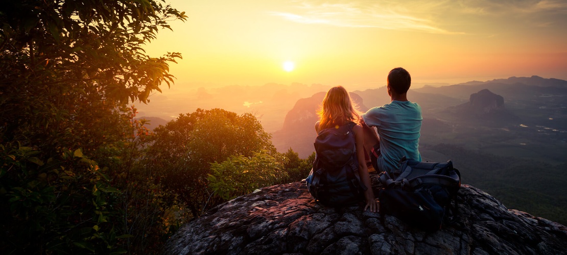 Couple watching the sunset in a natural setting Couple watching the sunset in a natural setting