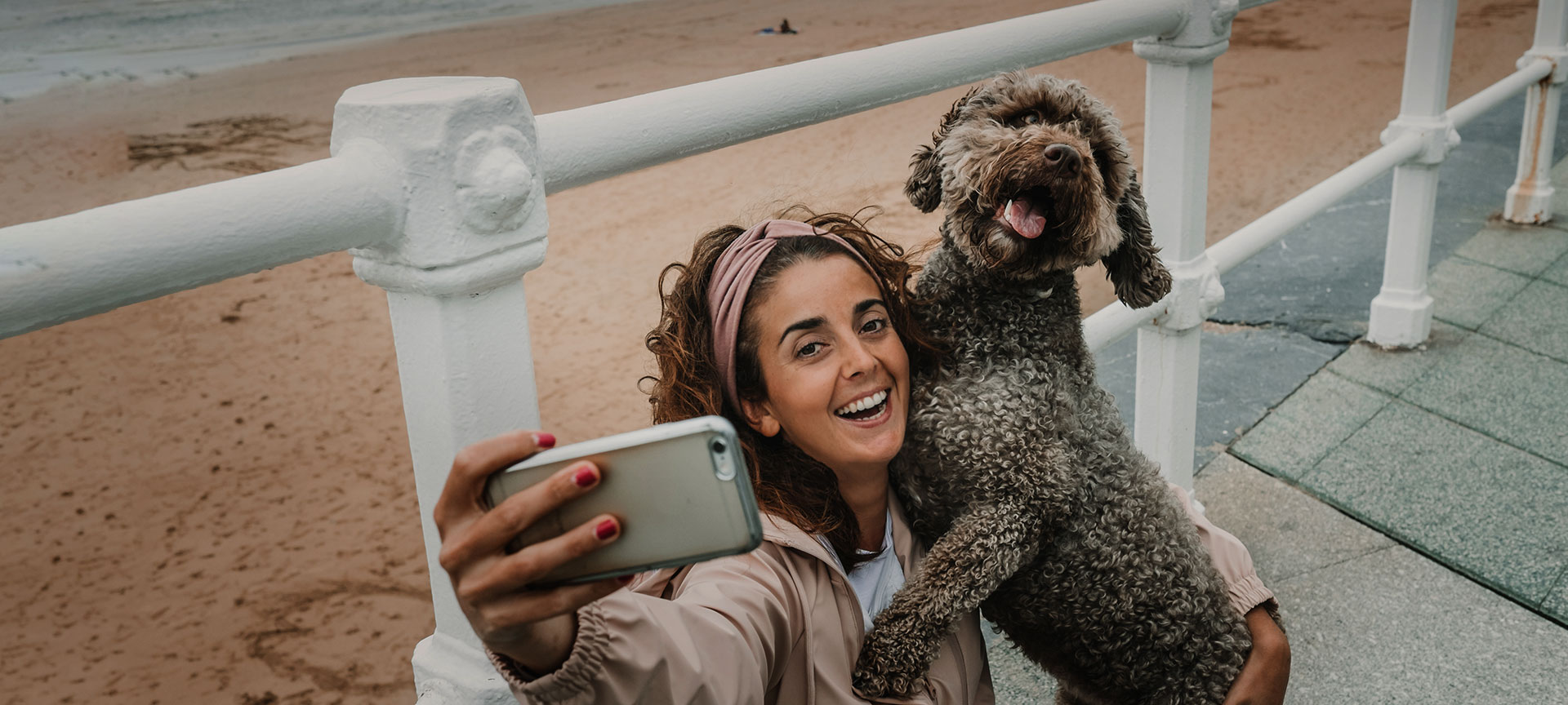 Touriste prenant un selfie avec son animal de compagnie sur une plage de Gijón, Asturies Touriste prenant un selfie avec son animal de compagnie sur une plage de Gijón, Asturies