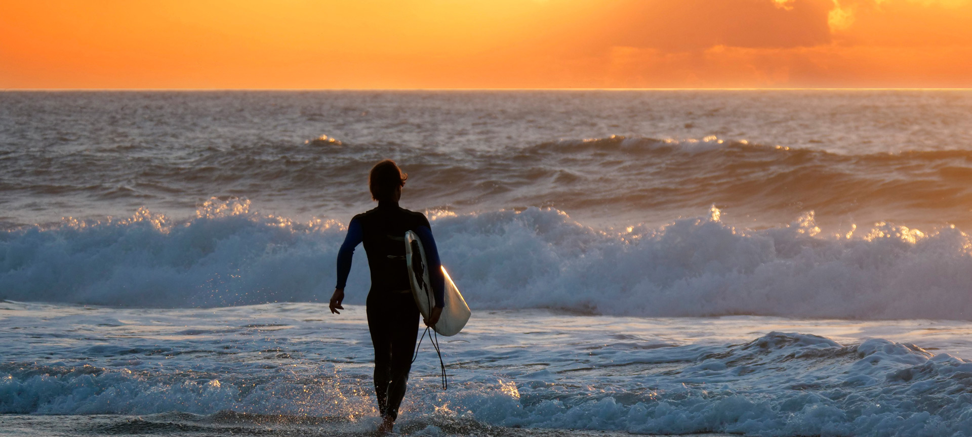 Surfer podziwiający zachód słońca na Fuerteventurze na Wyspach Kanaryjskich