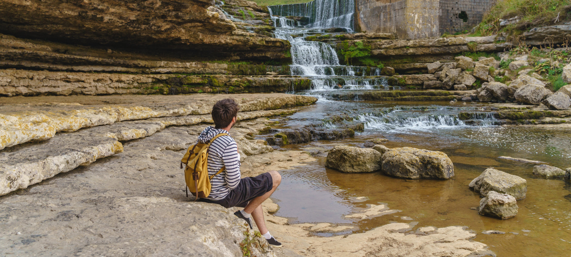Turista che contempla la cascata del Bolao a Toñanes, Cantabria