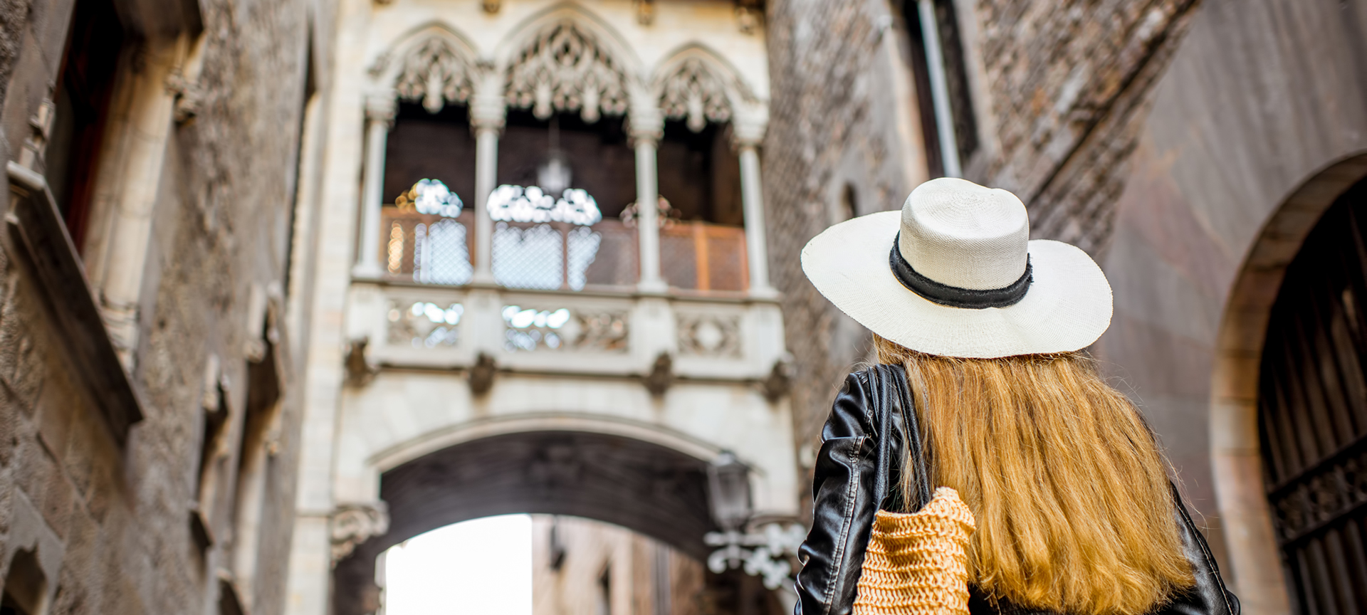 Tourist looking at the Bridge of Sighs in the old town of Barcelona