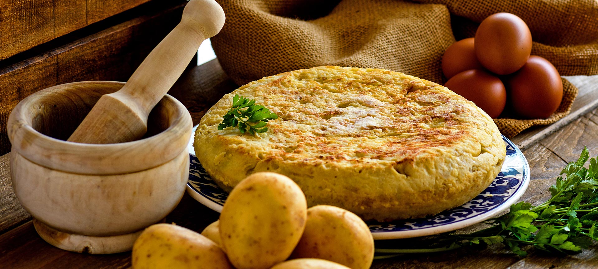 Spanish omelette with products to make it and a mortar Spanish omelette with products to make it and a mortar