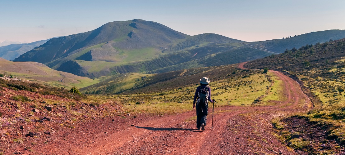 Hiker walking in the Sierra Cebollera mountain range on a sunny day, La Rioja Hiker walking in the Sierra Cebollera mountain range on a sunny day, La Rioja