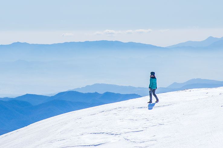 Hiker looking out over snowcapped mountains in Girona, Catalonia Hiker looking out over snowcapped mountains in Girona, Catalonia
