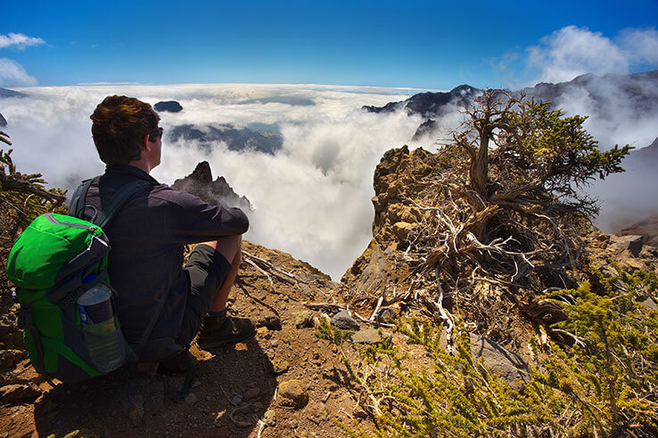 Hiker contemplating the views at the top of the mountain Hiker contemplating the views at the top of the mountain