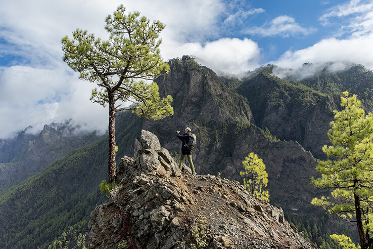 Hiker taking a photo from the top of the mountain Hiker taking a photo from the top of the mountain