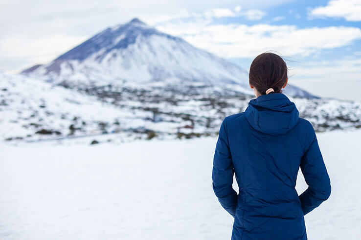Ragazza che osserva il vulcano innevato del Teide Ragazza che osserva il vulcano innevato del Teide