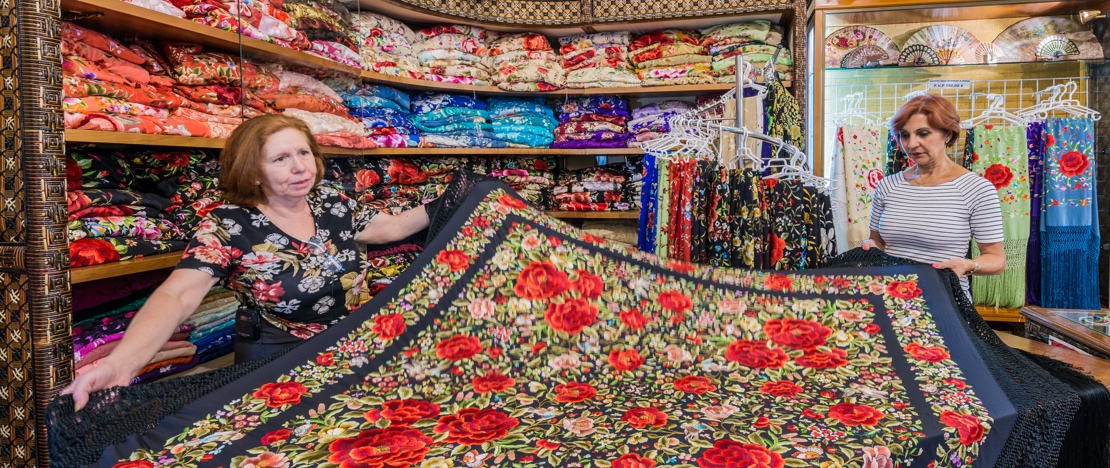 Una mujer comprando un mantón de Manila en una tienda de Sevilla Una mujer comprando un mantón de Manila en una tienda de Sevilla