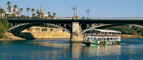 Boat crossing the Triana Bridge Boat crossing the Triana Bridge