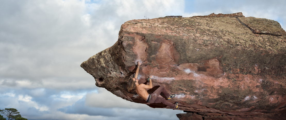 Mann klettert auf einen Felsblock in der Sierra de Albarracín in Teruel, Aragón, Spanien. Mann klettert auf einen Felsblock in der Sierra de Albarracín in Teruel, Aragón, Spanien.