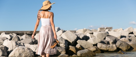 Donna che passeggia in riva al mare Donna che passeggia in riva al mare