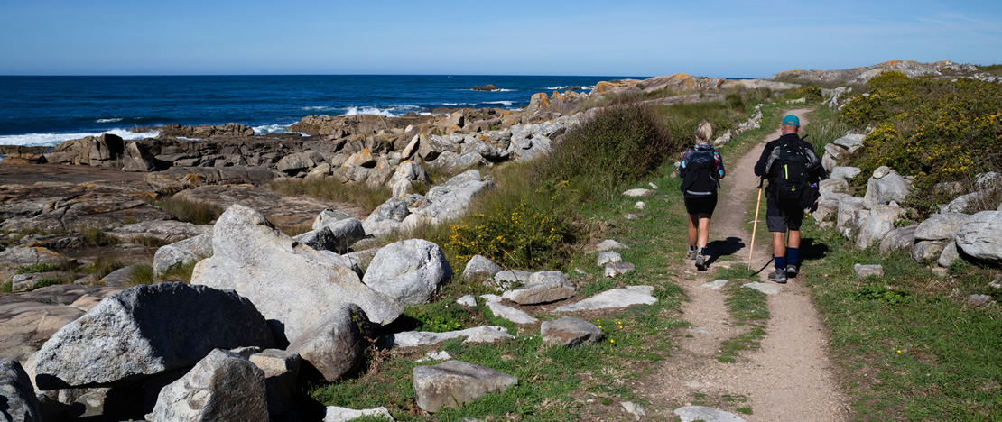 Dois peregrinos caminhando ao longo da costa em A Guarda