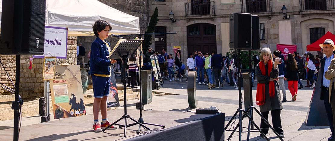 Child reading Don Quixote in front of the Barcelona Cathedral during Sant Jordi