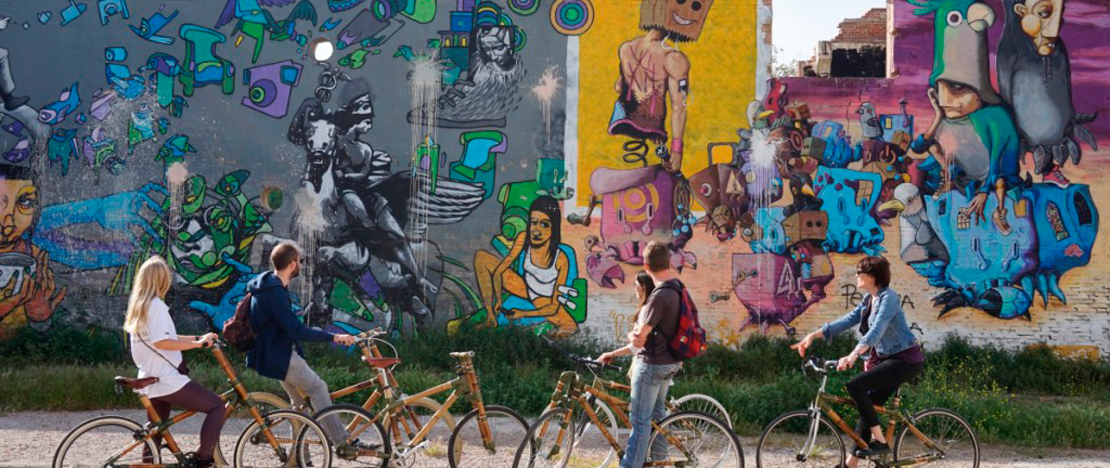 Turistas durante un tour de street art en bicicleta ecológica de Barcelona, Cataluña Turistas durante un tour de street art en bicicleta ecológica de Barcelona, Cataluña