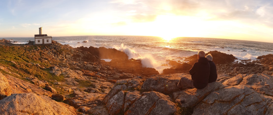 Turisti che contemplano il tramonto presso il faro di Corrubedo ad A Coruña, Galizia Turisti che contemplano il tramonto presso il faro di Corrubedo ad A Coruña, Galizia