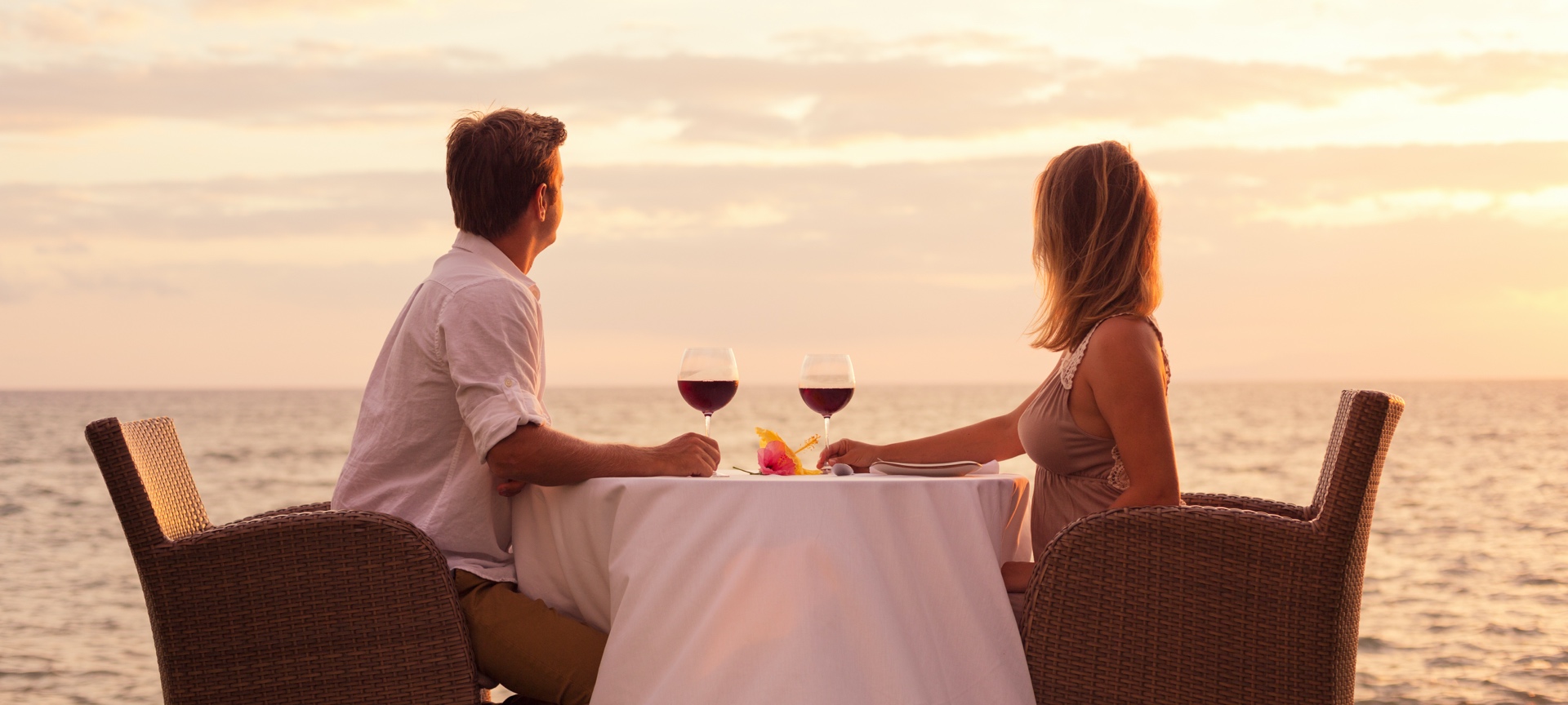 Couple enjoying a glass of wine by the sea Couple enjoying a glass of wine by the sea