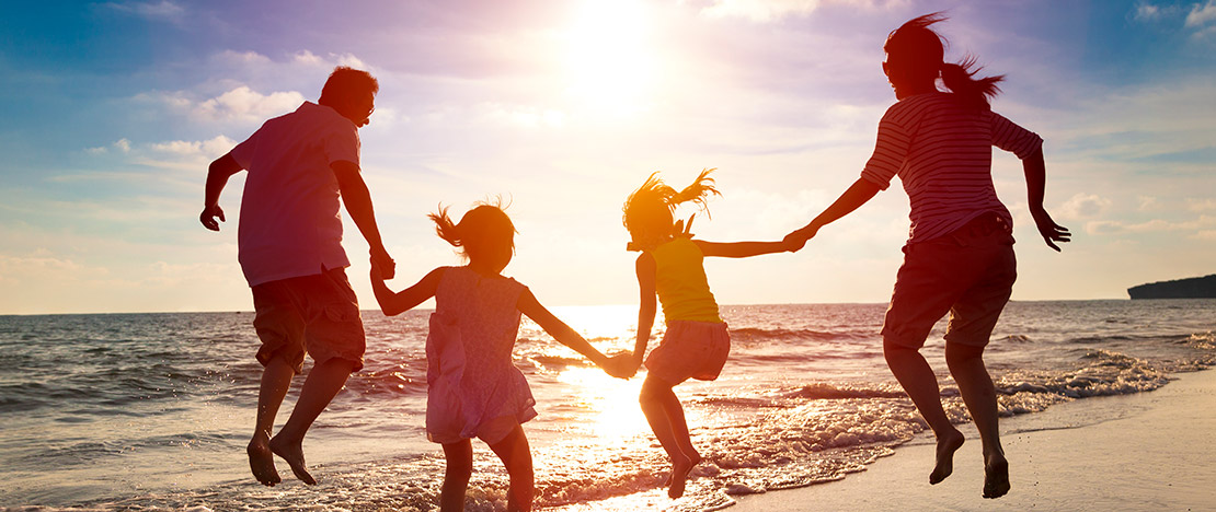 A family enjoying the beach at dusk A family enjoying the beach at dusk
