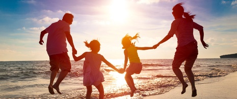 A family enjoying the beach at dusk A family enjoying the beach at dusk