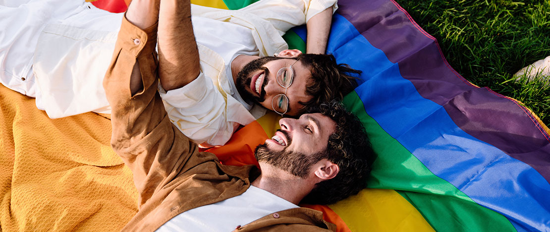 Couple gay sur le drapeau arc-en-ciel Couple gay sur le drapeau arc-en-ciel