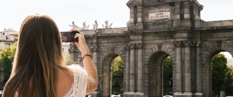 Turysta fotografujący Puerta de Alcalá w Madrycie, Wspólnota Madrytu Turysta fotografujący Puerta de Alcalá w Madrycie, Wspólnota Madrytu