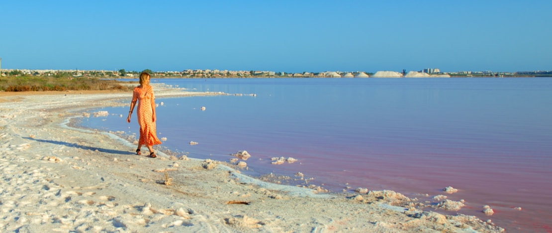 Tourist looking at the pink lagoon of La Mata y Torrevieja in Alicante, region of Valencia