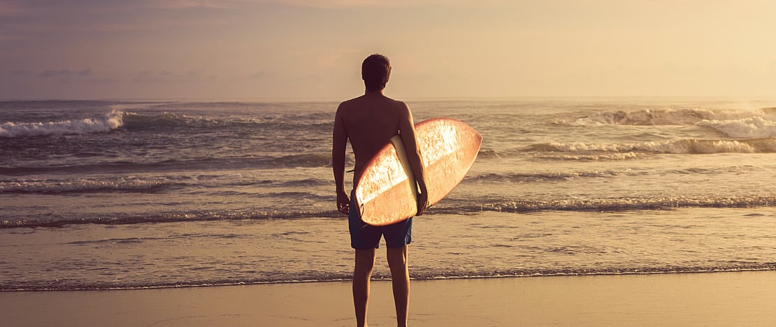 Un surfeur contemple les vagues depuis le rivage Un surfeur contemple les vagues depuis le rivage