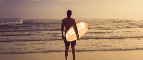 Un surfeur contemple les vagues depuis le rivage Un surfeur contemple les vagues depuis le rivage
