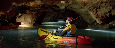 Tourist caving in a kayak at the Coves de Sant Josep, in La Vall d’Uixó, Castellón, region of Valencia Tourist caving in a kayak at the Coves de Sant Josep, in La Vall d’Uixó, Castellón, region of Valencia