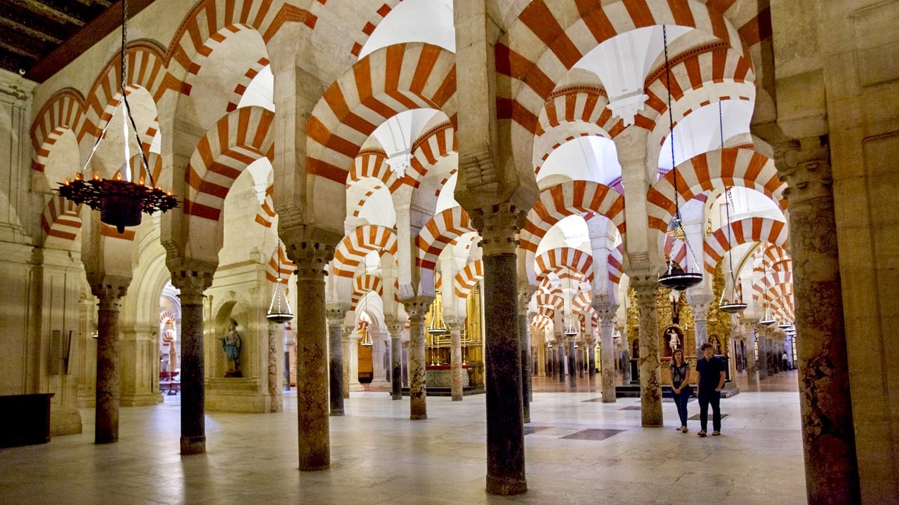 Un couple marchant dans la salle des colonnes de la mosquée-cathédrale de Cordoue Un couple marchant dans la salle des colonnes de la mosquée-cathédrale de Cordoue
